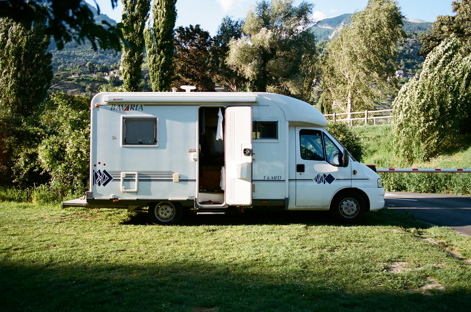 white and brown rv trailer on green grass field during daytime, RV